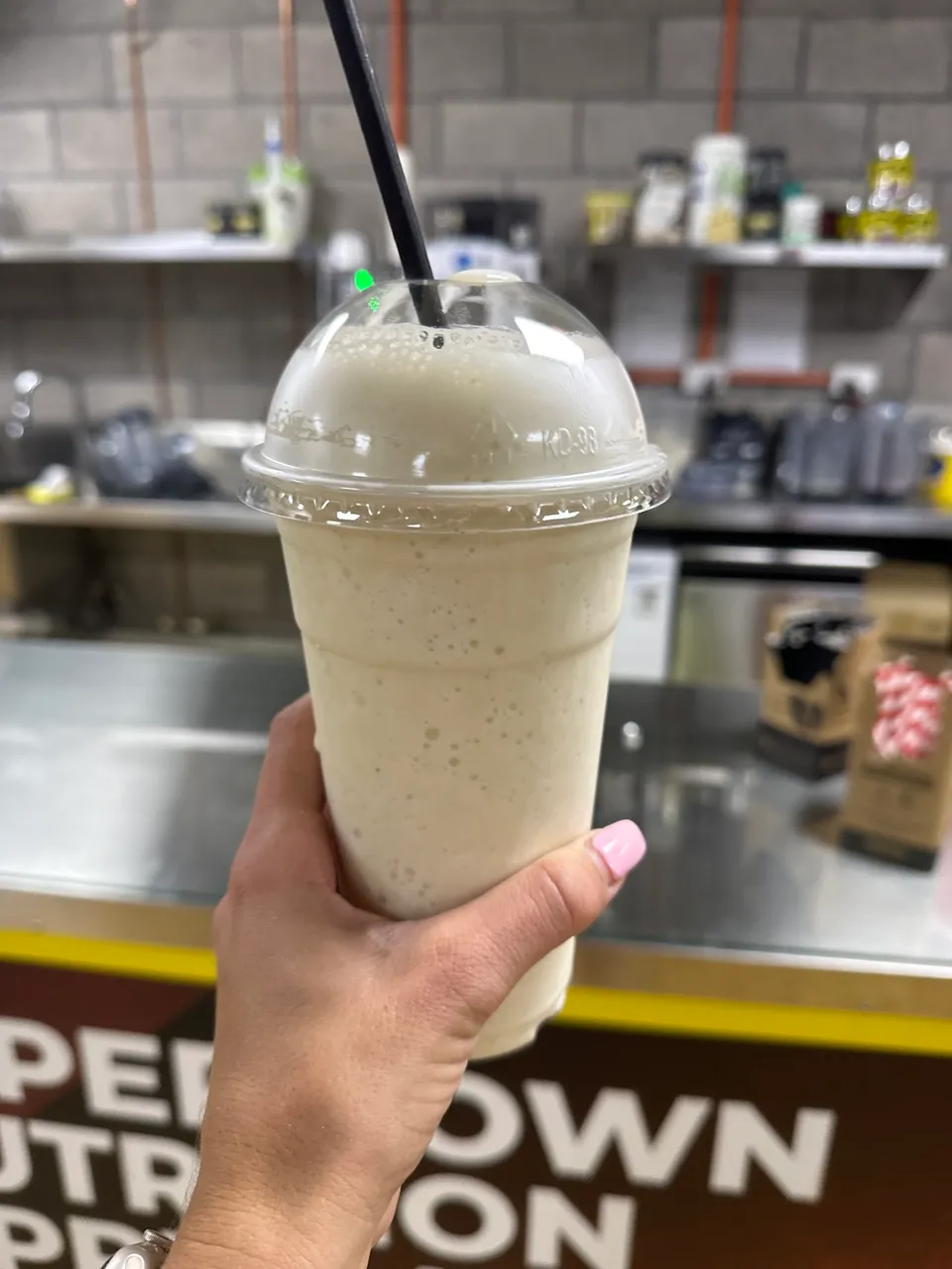 Freshly blended protein shake held up at the Camperdown Nutrition smoothie bar